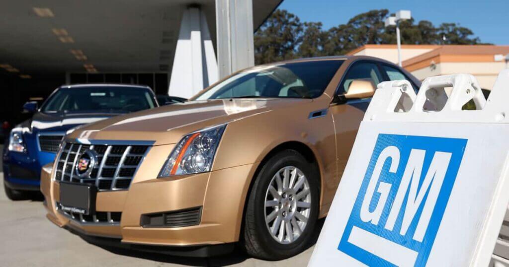 A Cadillac CTS is parked in front of a GM dealership.